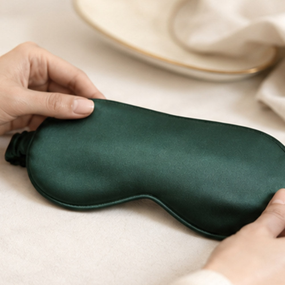 Hands carefully checking and shaping a Forest Whisper silk sleep mask